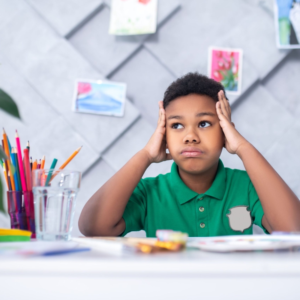 reflections-dark-skinned-boy-primary-school-age-touching-head-with-hands-looking-pensively-up-aside-sitting-table-with-drawing-colored-pencils-room_compressed