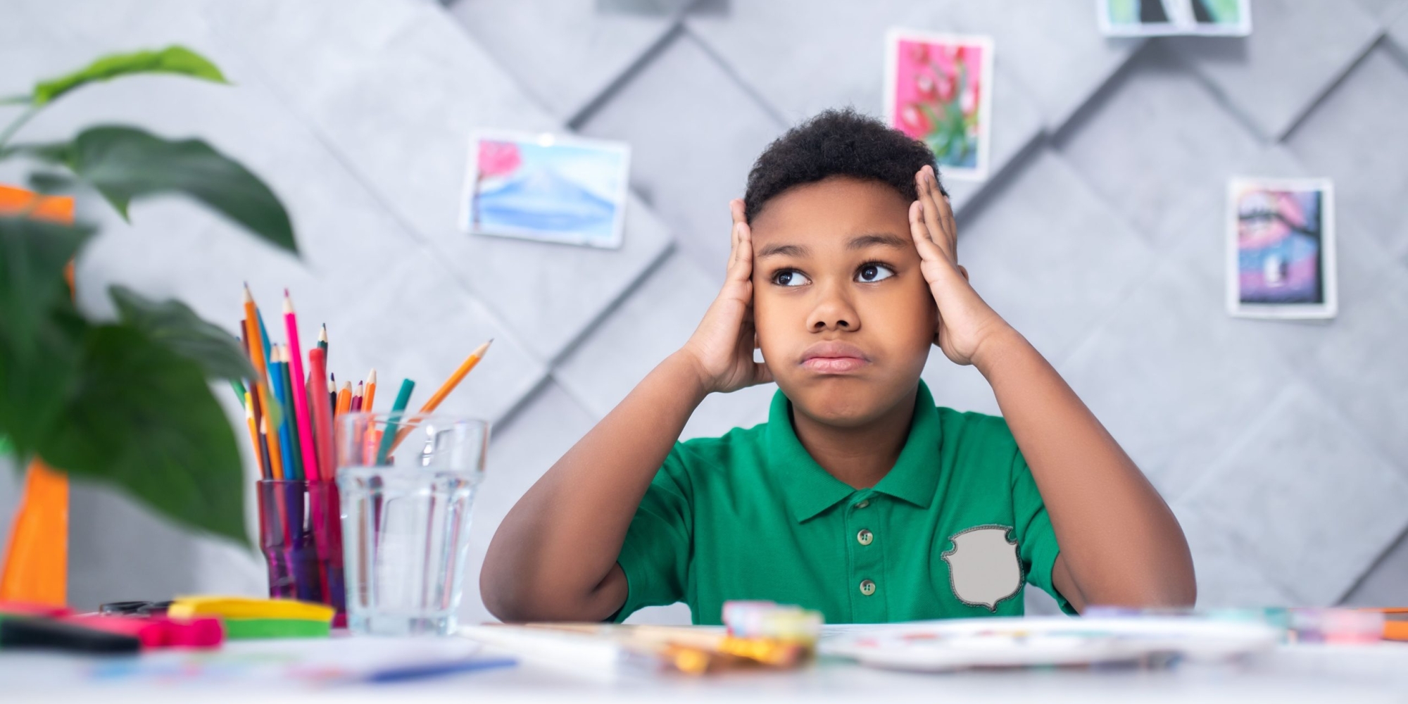 reflections-dark-skinned-boy-primary-school-age-touching-head-with-hands-looking-pensively-up-aside-sitting-table-with-drawing-colored-pencils-room_compressed